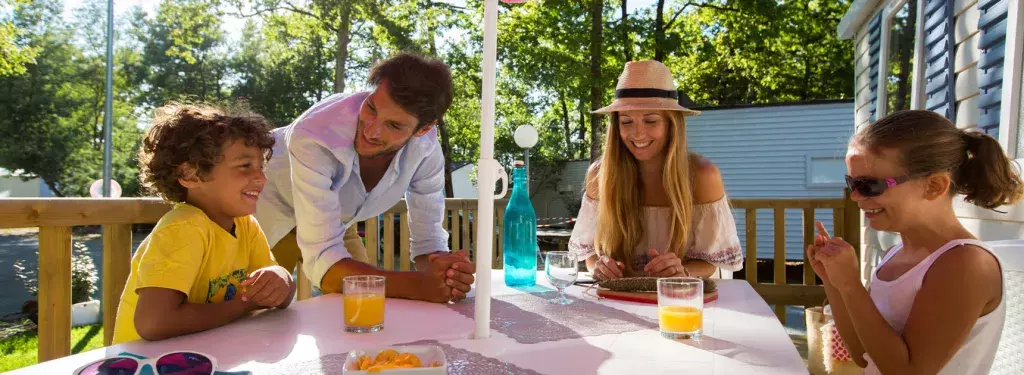 Famille sur la terrasse de leur mobil home Domaine de Soulac